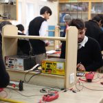 Estudantes trabalham em projetos de eletrônica durante uma aula prática em laboratório.