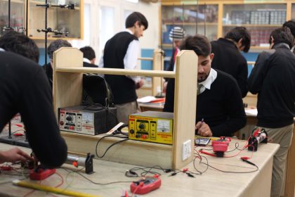 Estudantes trabalham em projetos de eletrônica durante uma aula prática em laboratório.