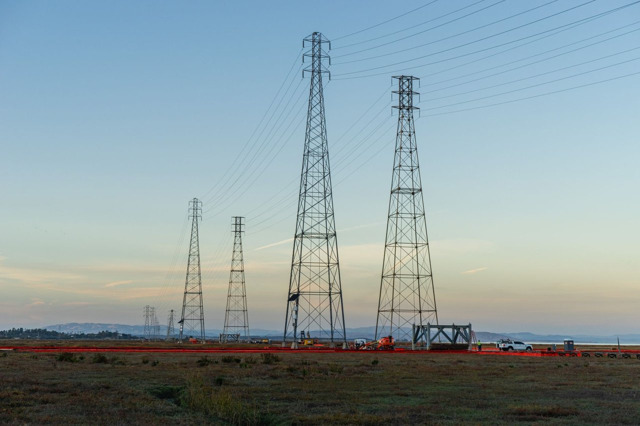 Torres de transmissão de alta tensão em um campo aberto ao entardecer